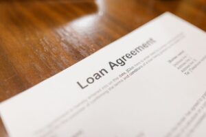 Close-up of a loan agreement document being signed, representing co-signing a loan
