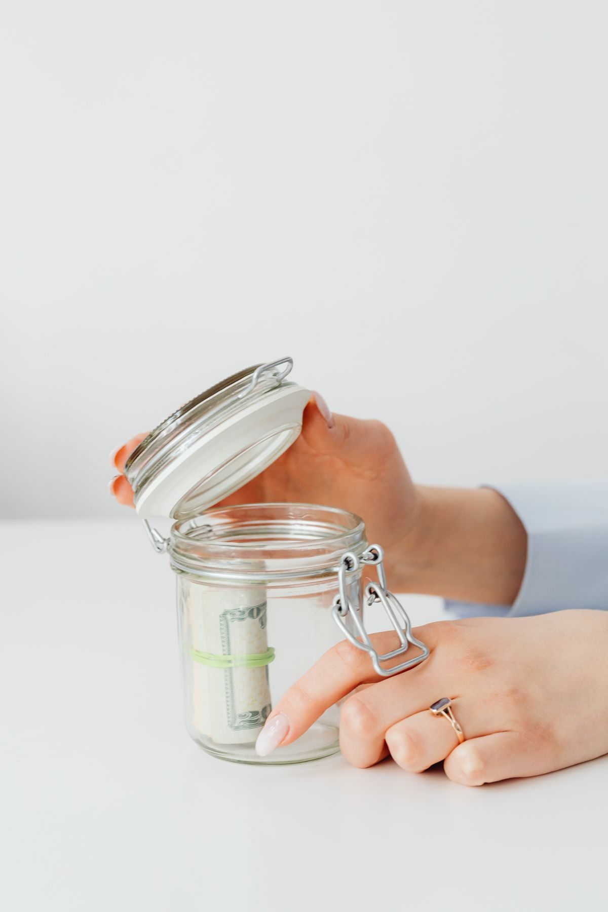 Hands placing money into a jar, representing how simple and compound interest grow savings differently